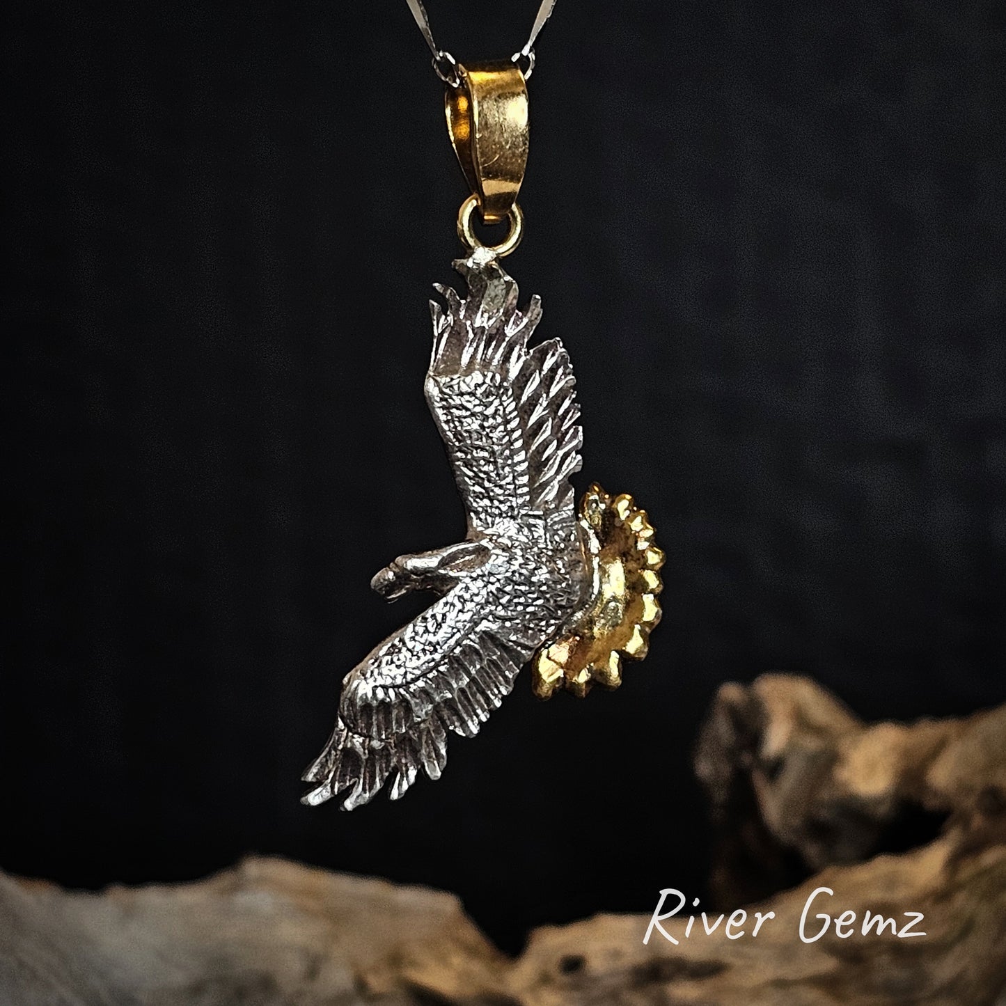 Eagle pendant with gold accents on a dark background, featuring 'River Gemz' branding.