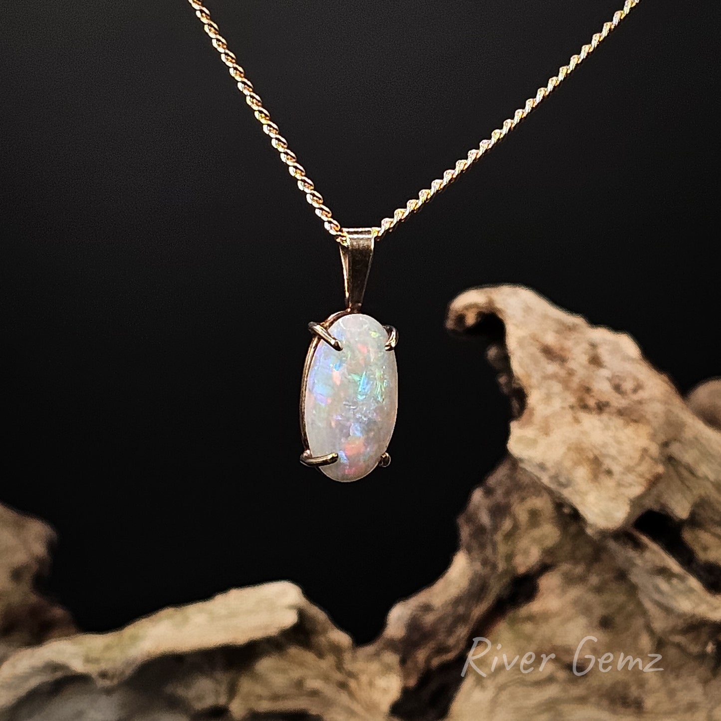 Opal pendant necklace on a gold chain with a dark background and 'River Gemz' branding.