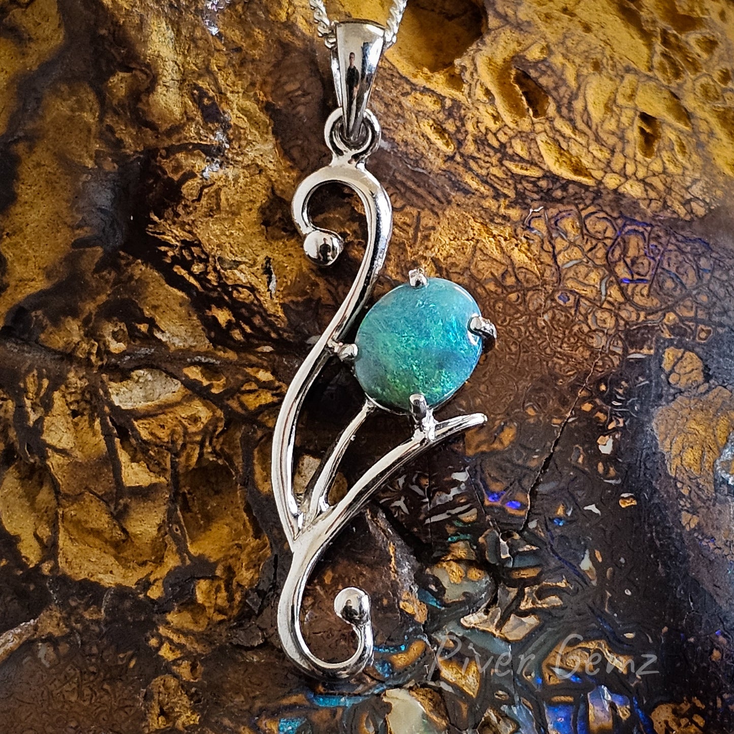 Sterling silver necklace with claw set blue and green semi-black opal featured.