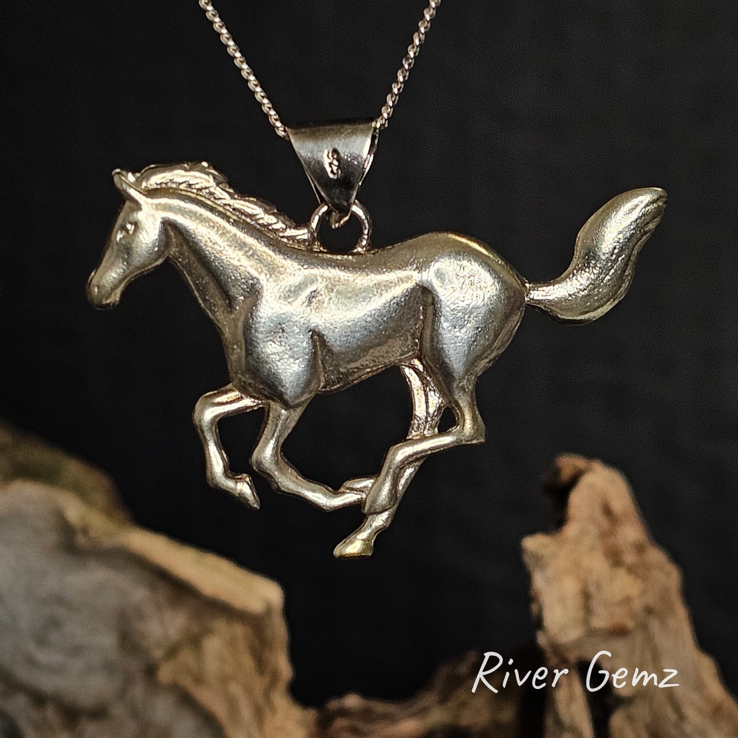 Silver horse pendant on a chain against a dark background with 'River Gemz' branding.