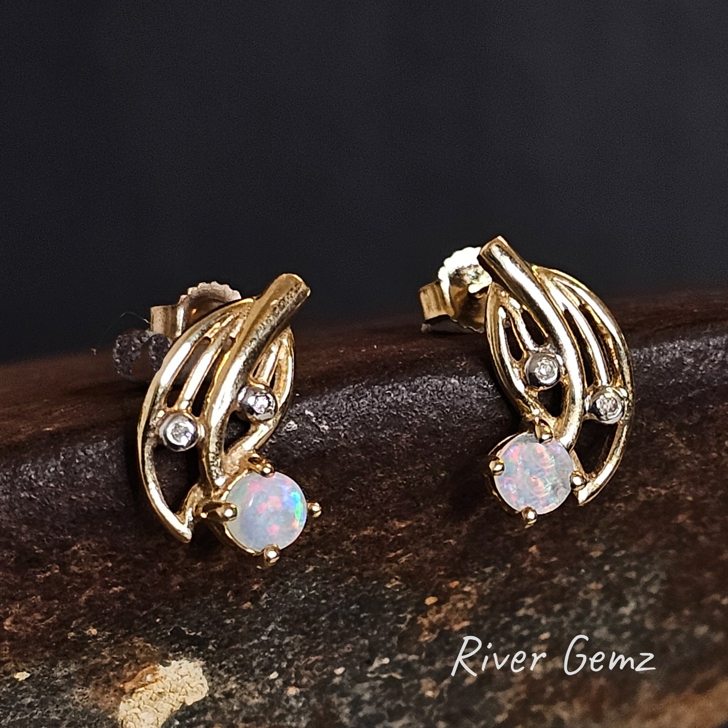 Round light multi-coloured opals claw set in gold earrings with 2 white diamonds.