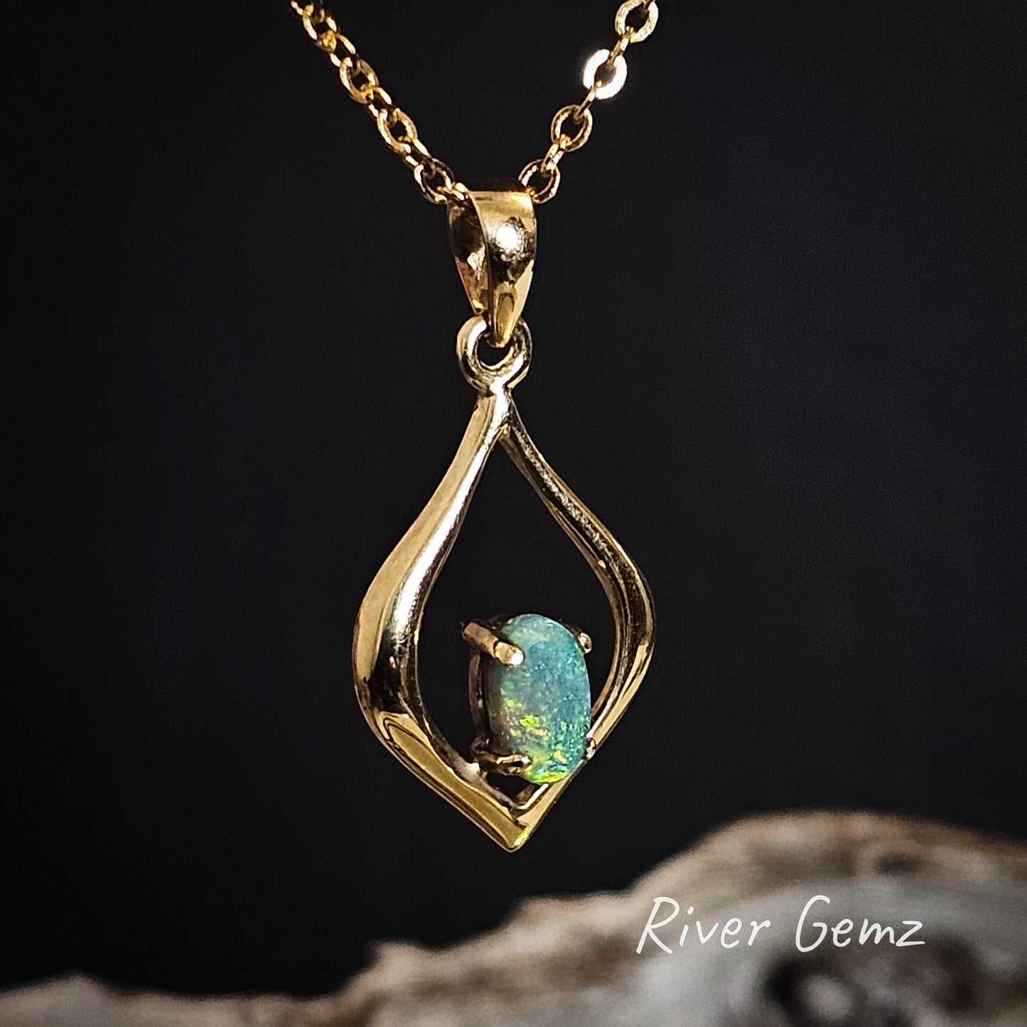 Black opal claw set in yellow gold pendant.