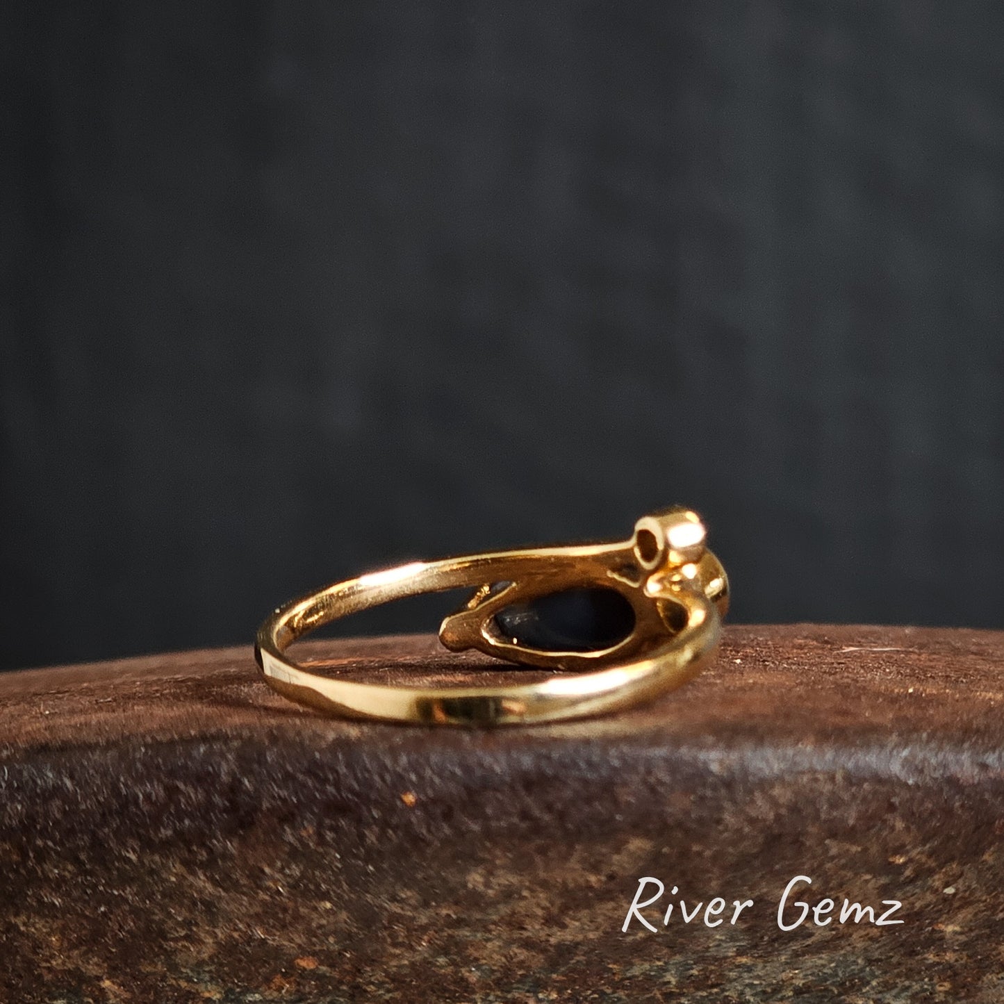 Rear of the gold ring shows the black base of the black opal set in it. The gold band is of uniform thickness.