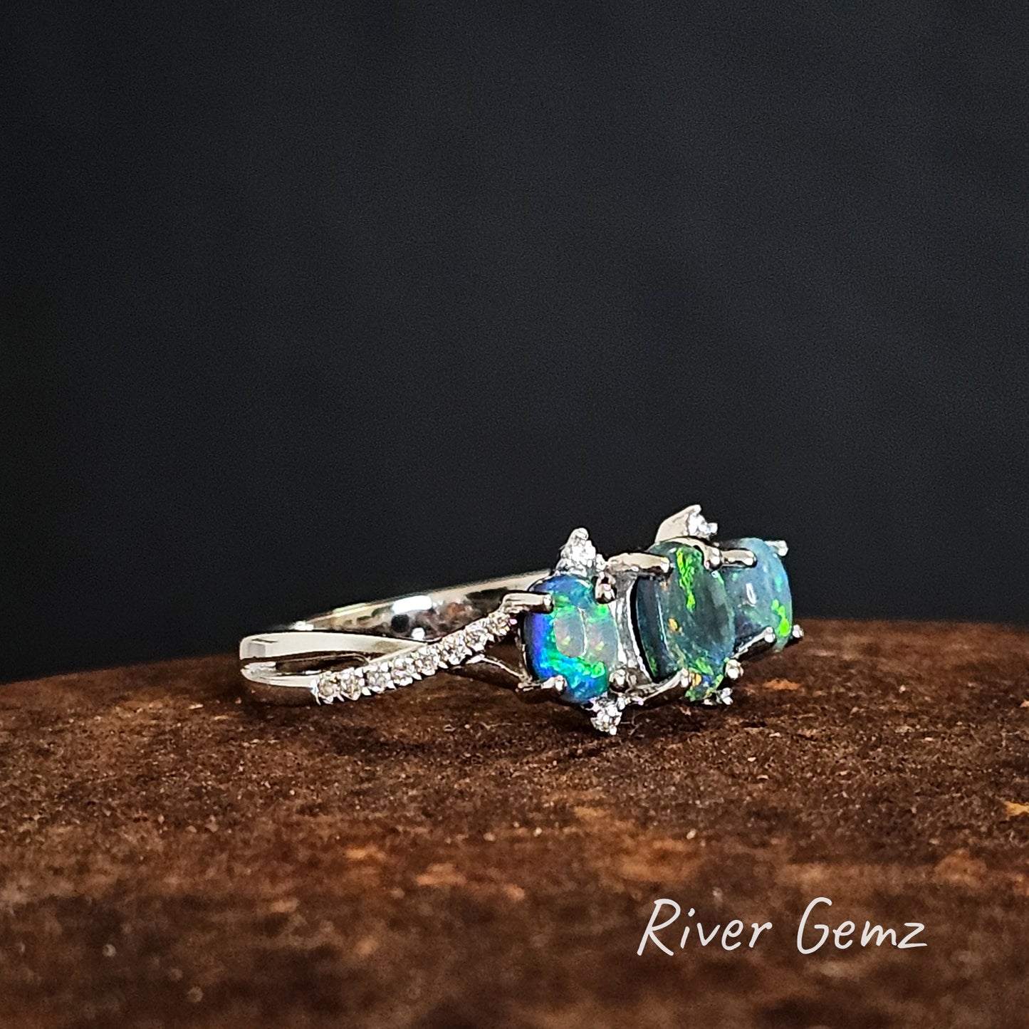 Three blue and green opals and diamonds set in 18K white gold modern design ring.