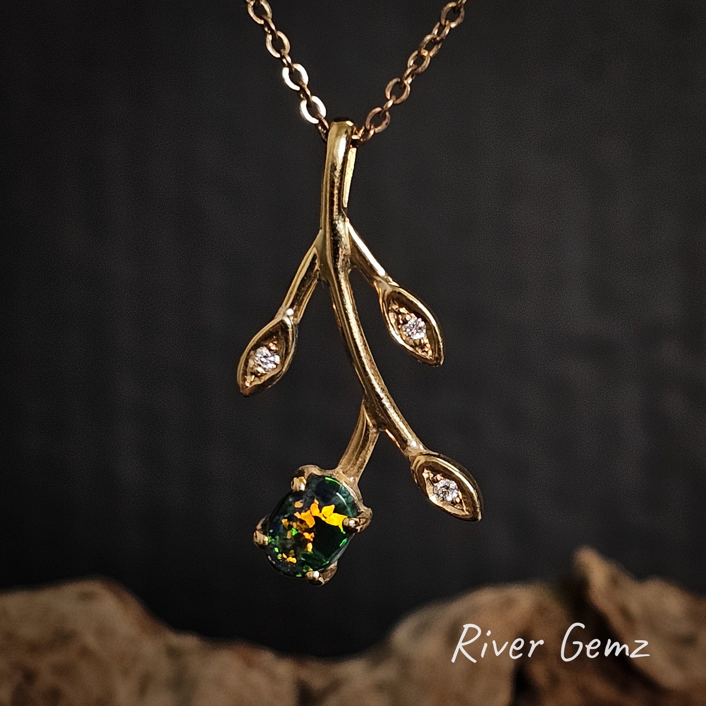 Oval shaped black opal claw set in flower designed gold pendant with diamonds in the three leaves.