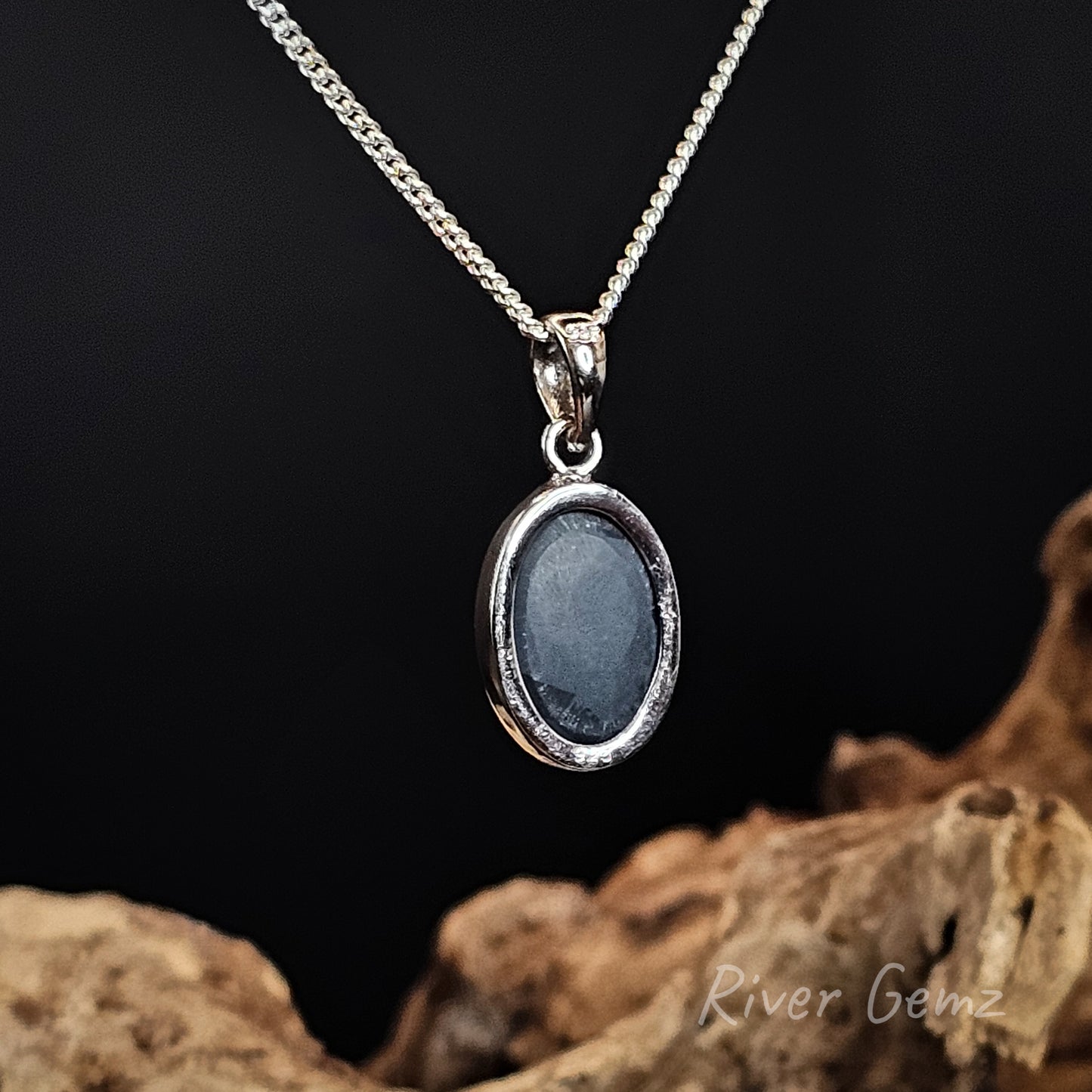 Rear view of the necklace shows the dark base tone of the black opal on a dark background