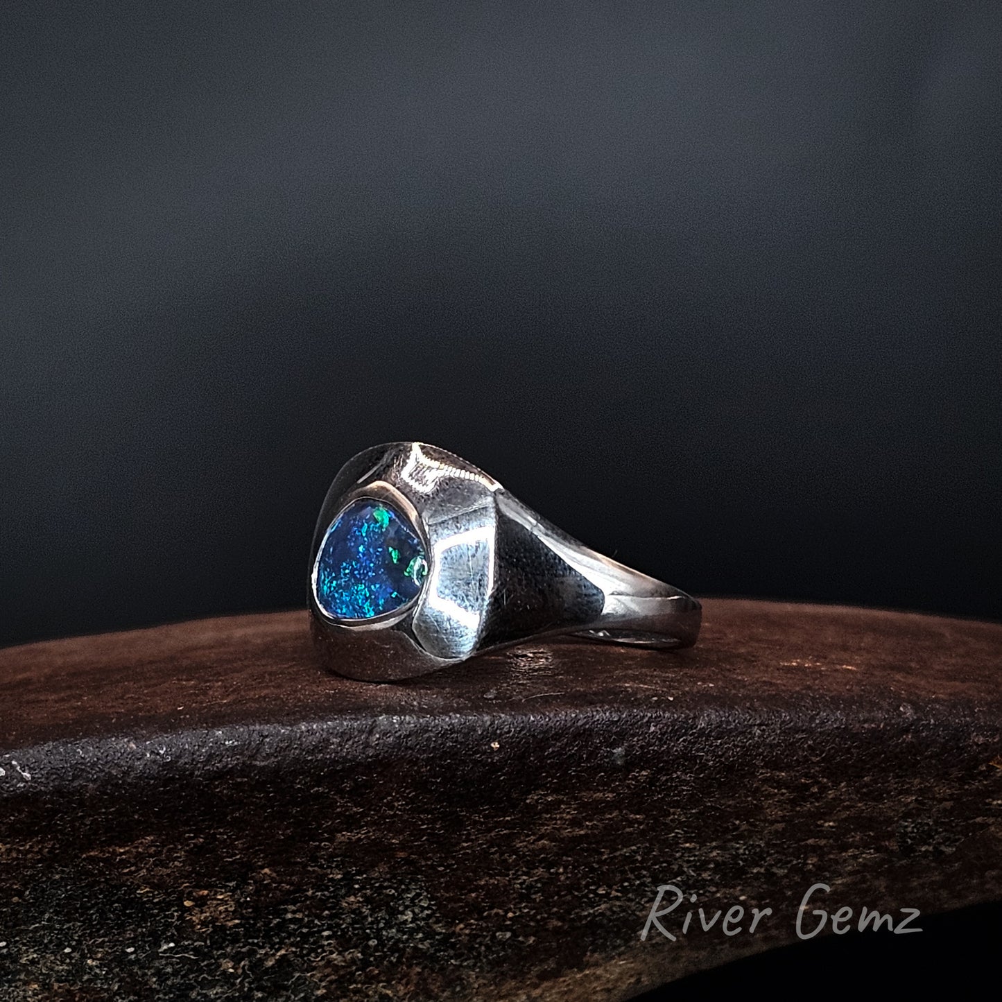 Side view of the ring shows the lines of the sterling silver ring with vivid blue coloured black opal.