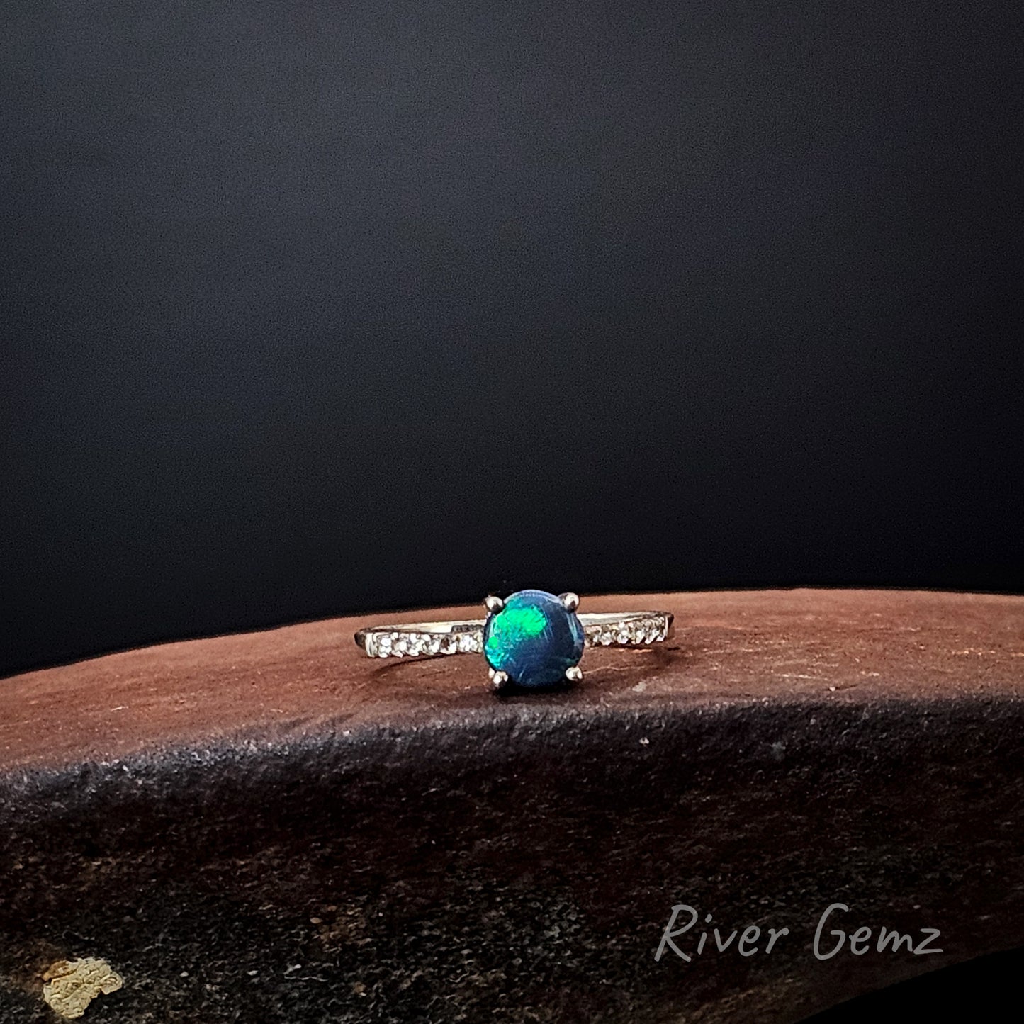 Bright green and dark blue opal claw set in sterling silver ring.