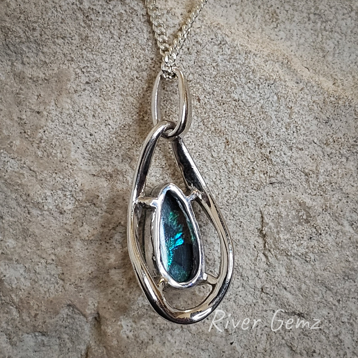 Back of opal pendant shown. Background of the photo is white sandstone.
