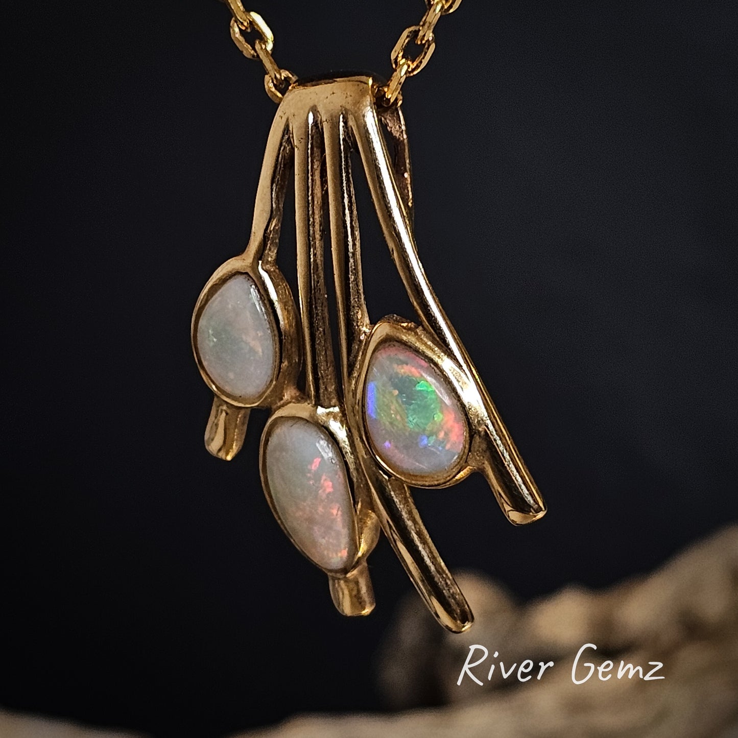 Three green, red and blue opals besel set in yellow gold pendant.