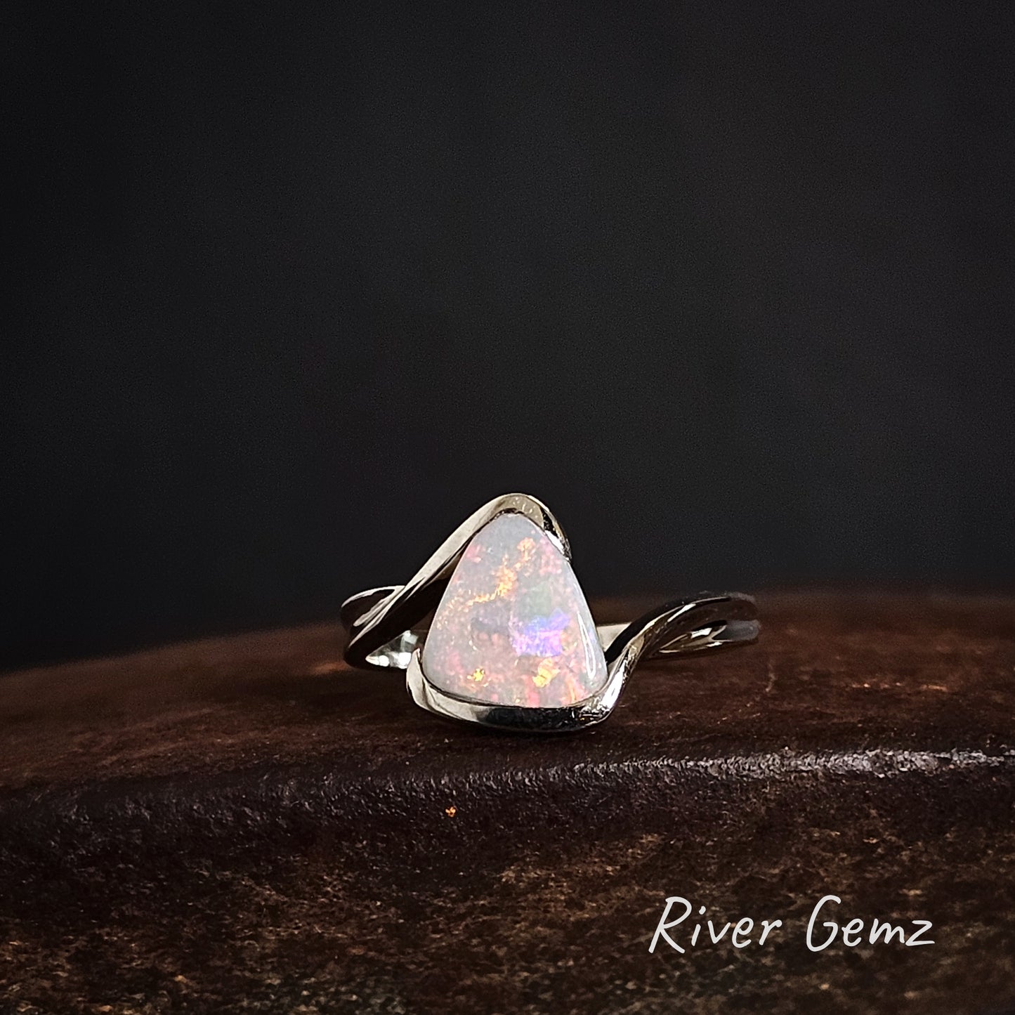 Opal ring with silver setting on a dark background, featuring the brand 'River Gemz'.