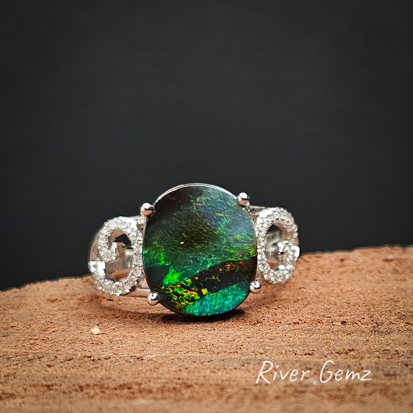 Front view shows splashes of orange in the black stripe in the black boulder opal.