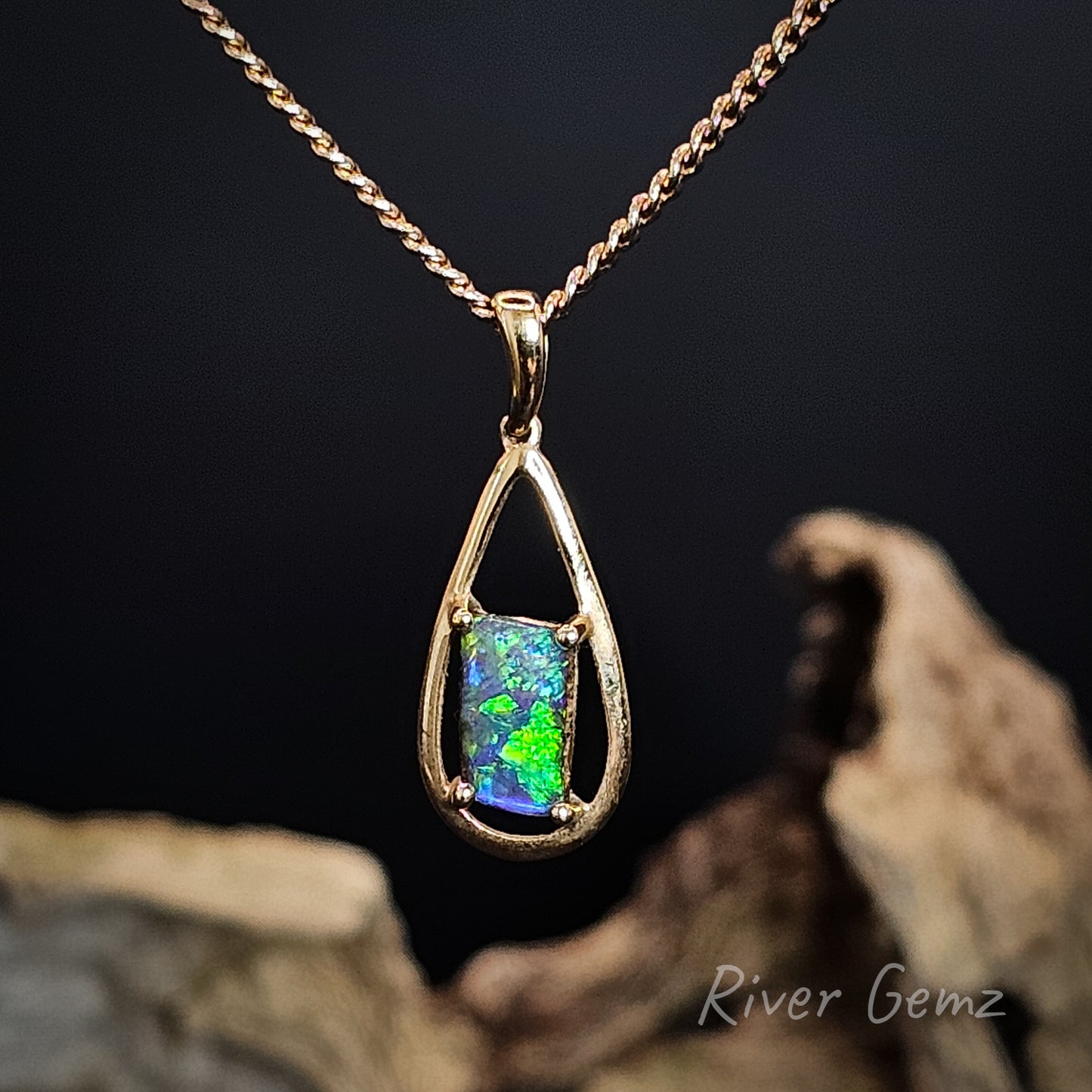 Opal pendant on a gold chain with a dark background