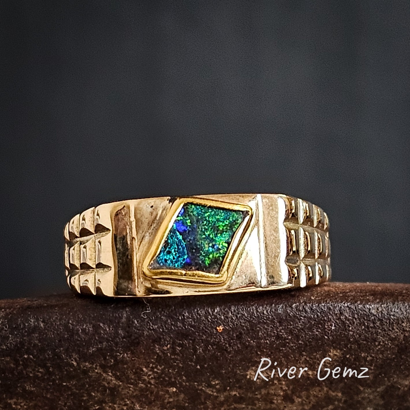 Boulder opal besel set in high grade yellow gold men's ring.