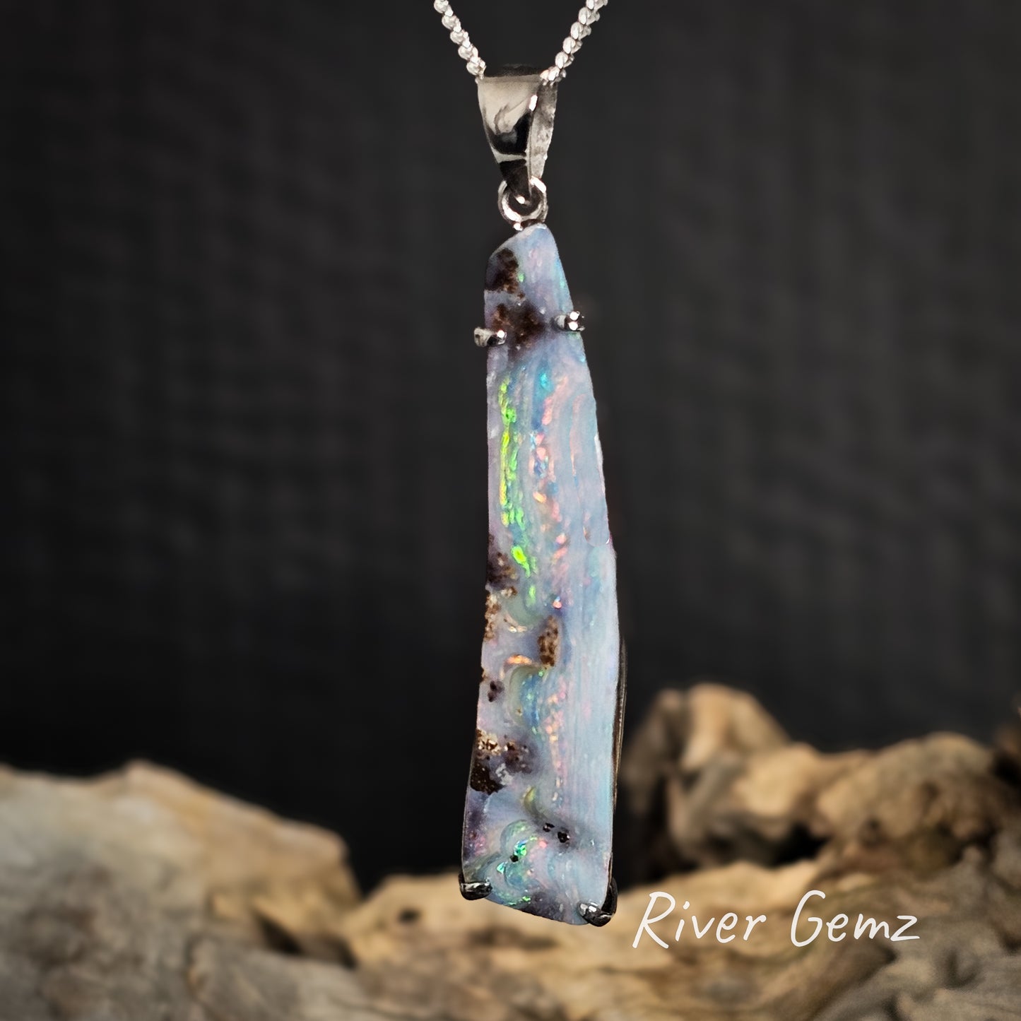 Mult-coloured boulder opal pendant necklace on a dark background with 'River Gemz' branding.