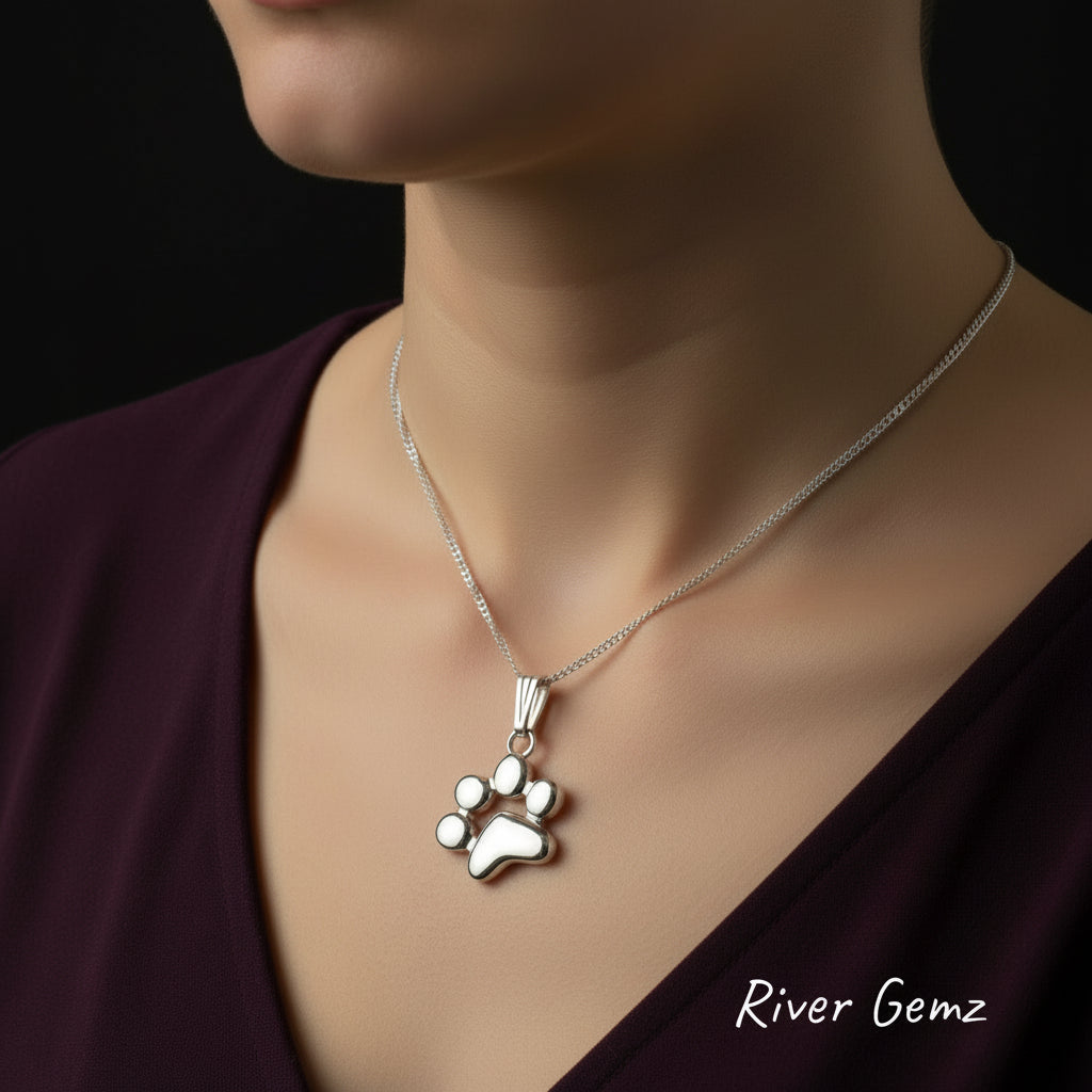 Silver paw print pendant being worn by a woman.