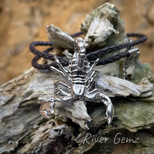 Necklace with a silver scorpion with tail curled. No bail in the design with the leather necklet passing through the rear of the scorpion.