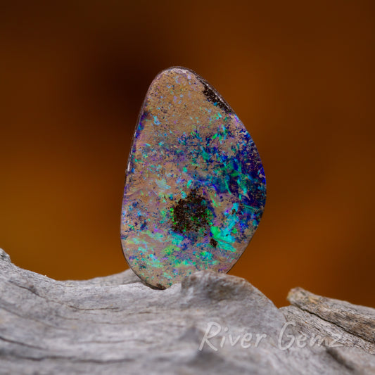 Blue and green flashes of colour interspersed amongst the sandstone and ironstone in this boulder opal.