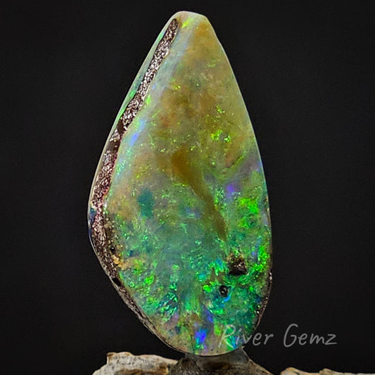 A slightly side on view of the boulder opal with vibrant greens. 