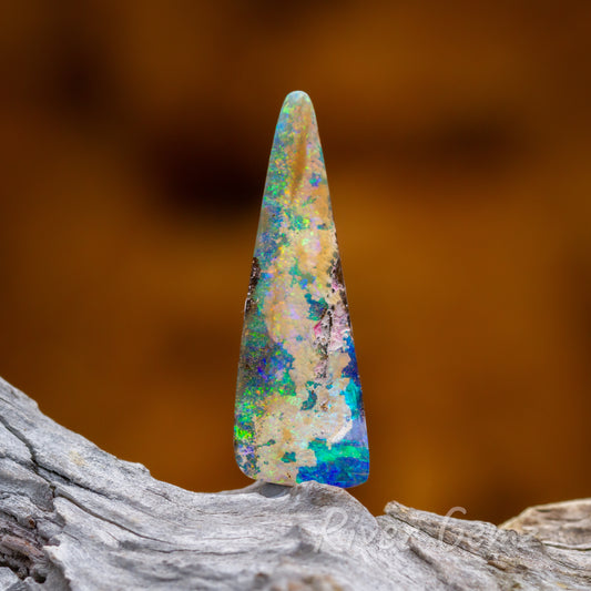 A long triangular shaped colourful loose opal.