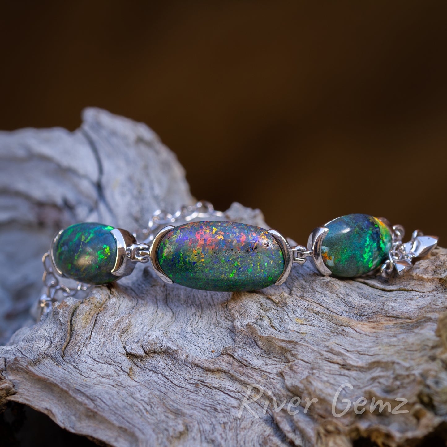 3 oval shaped equally colourful opals with the largest centred. 