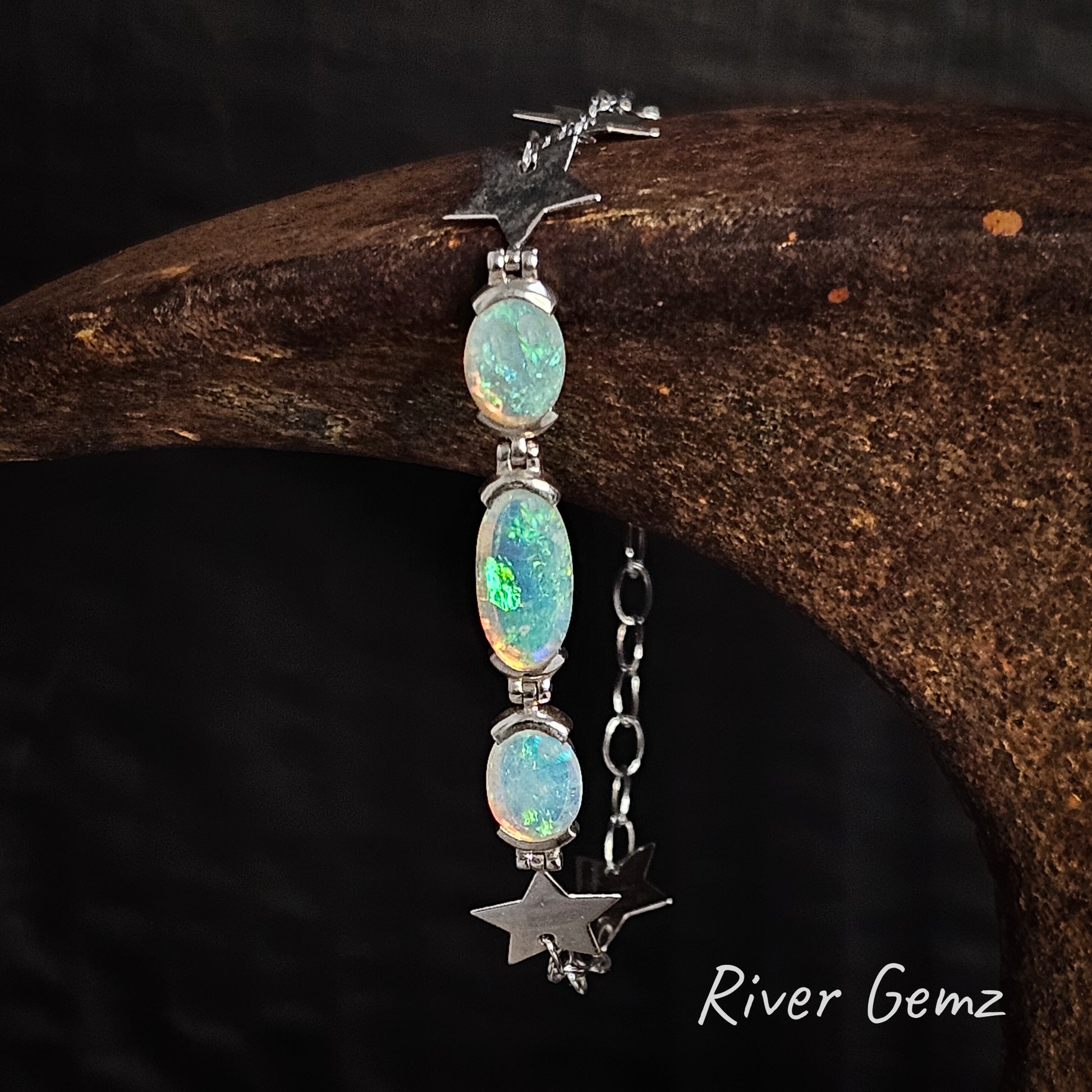 Three green light opals set in sterling silver bracelet with stars part of the chain link.