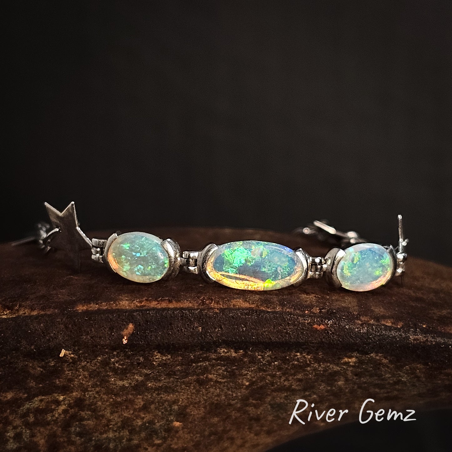 Three oval shaped green crystal opals partial besel set in sterling silver bracelet.