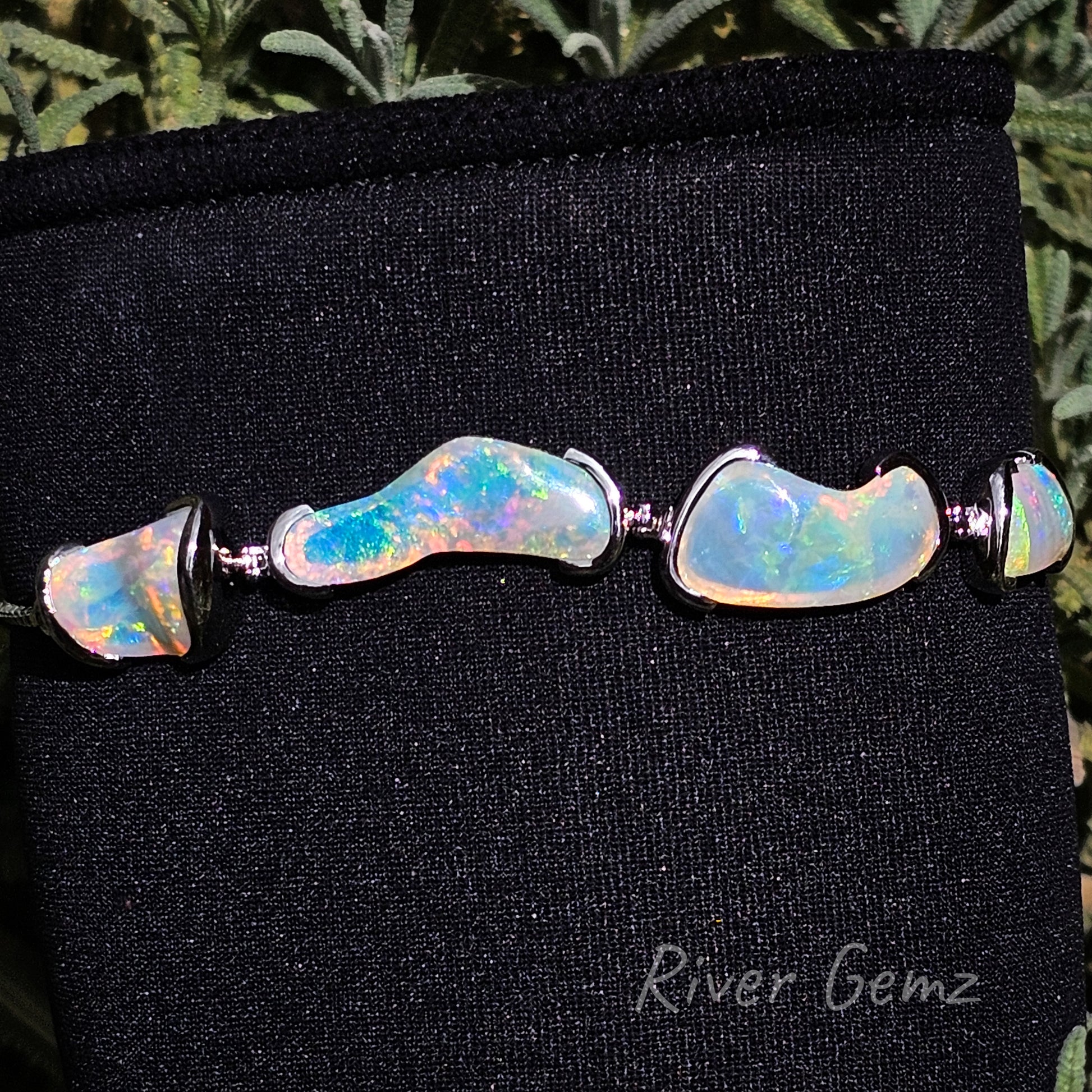 4 light unusually shaped opals partial besel set in silver bracelet.