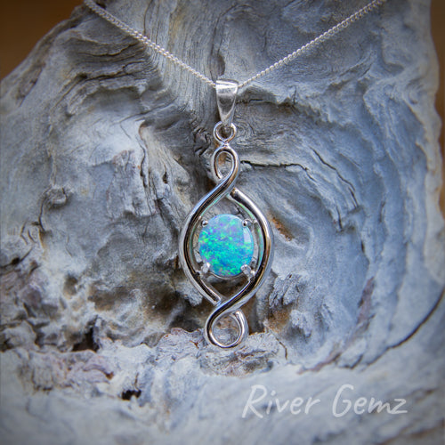 Oval-shaped blue-green opal claw set in modern design silver necklace.