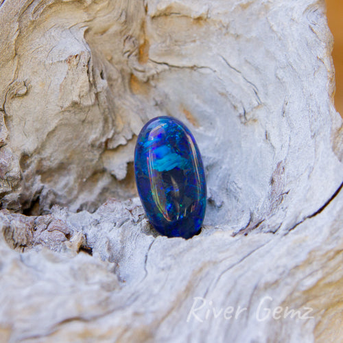 Oval shaped dark blue unset opal with exceptional polish.