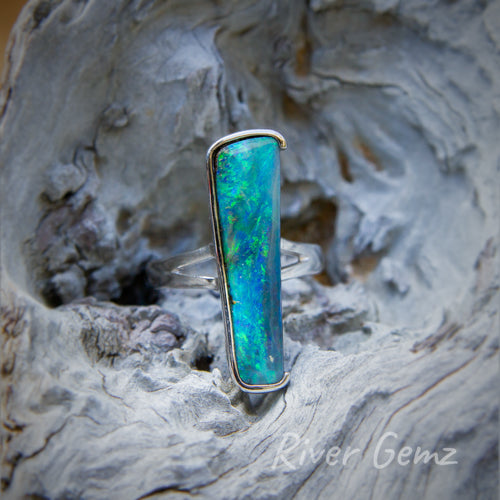 Large long dark blue and green opal partial besel set in silver ring.