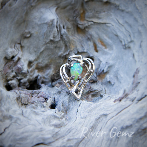 Tear drop shaped green opal at the heart of a strawberry shaped silver ring.