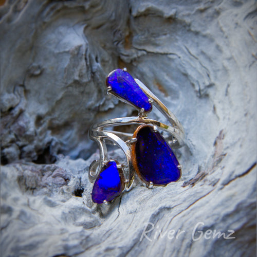 3 large dark blue boulder opals claw set in a modern and uniquely designed silver ring.