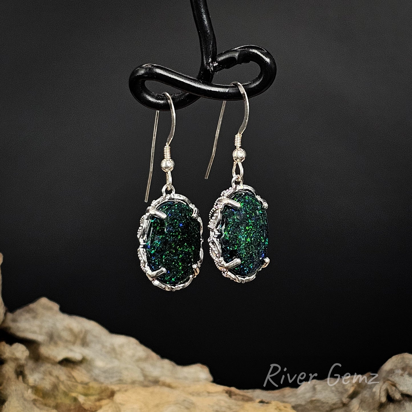 Large domed speckled green opals claw set in silver shepherd hooks.