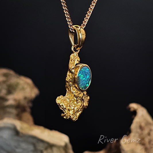 Gold pendant with a black opal and a natural nugget on a dark background