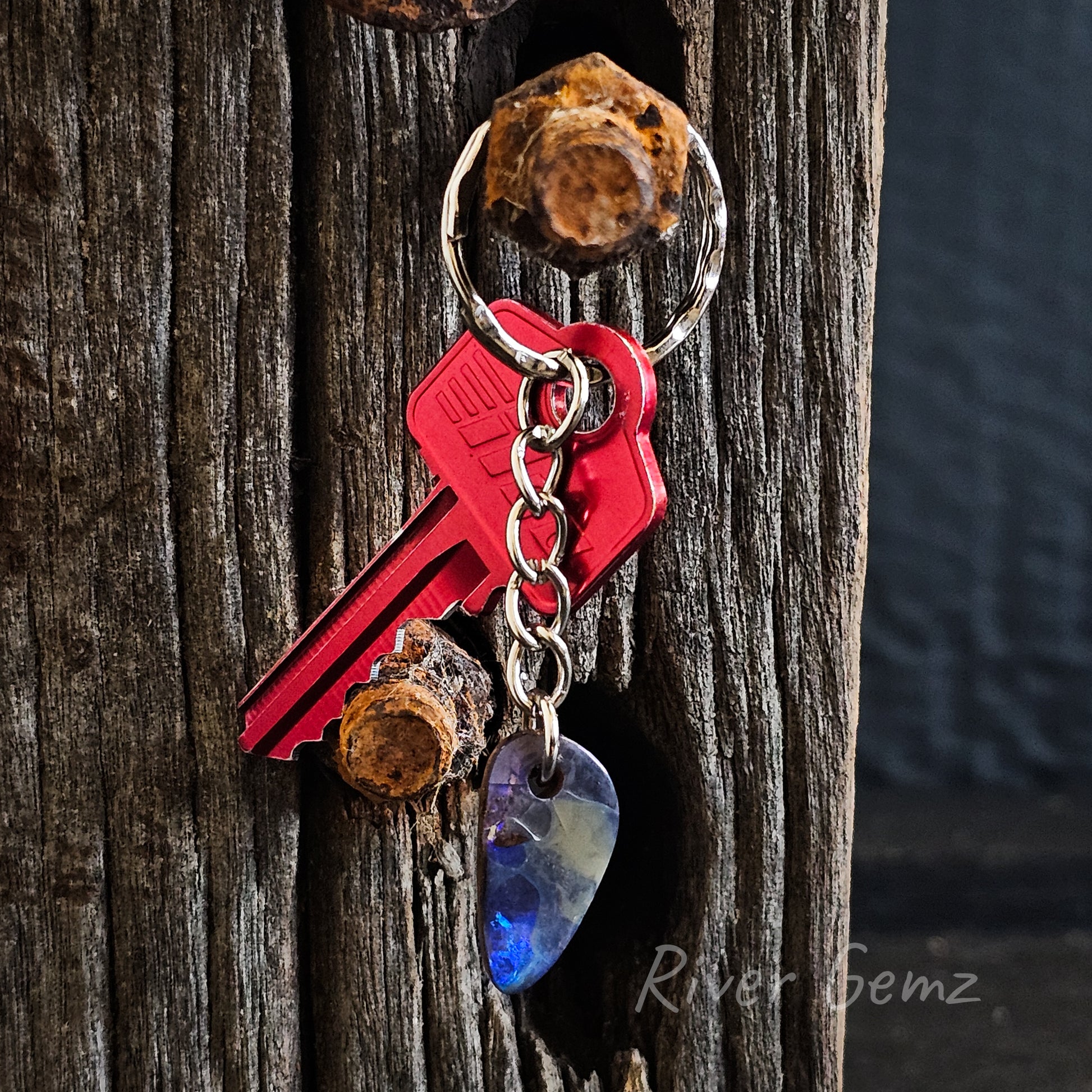 Rounded triangular shaped boulder opal drilled to secure 5 link key chain.