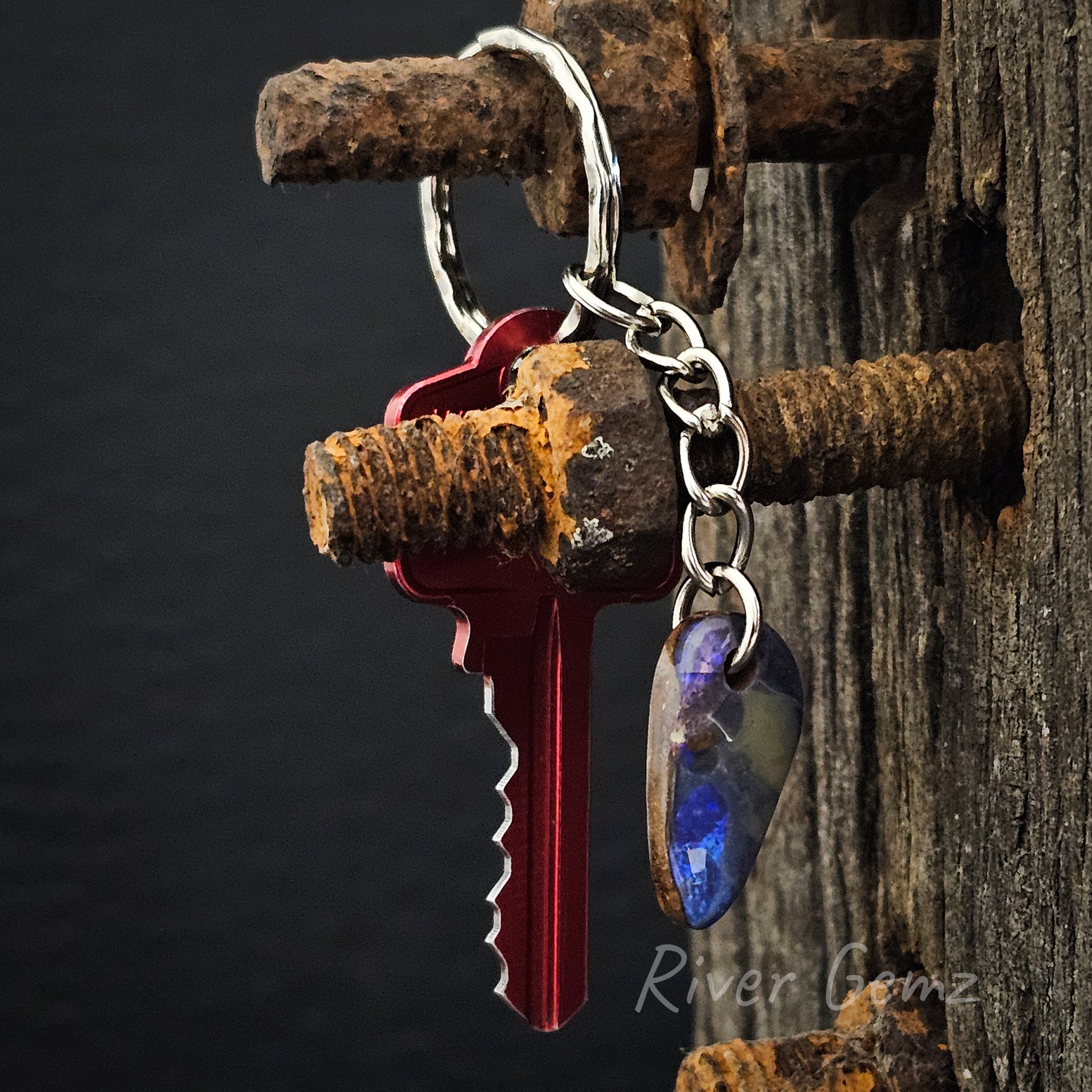 Blue and purple boulder opal key ring photographed with red key.