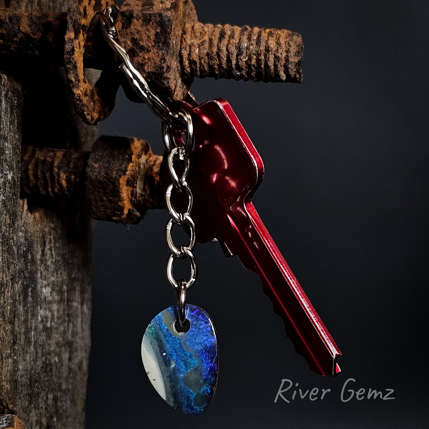 Key ring with a blue and white boulder opal on a dark background