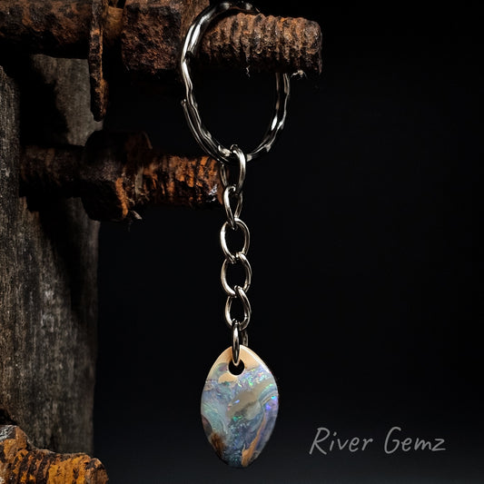 Keychain with a colorful boulder opal on a dark background