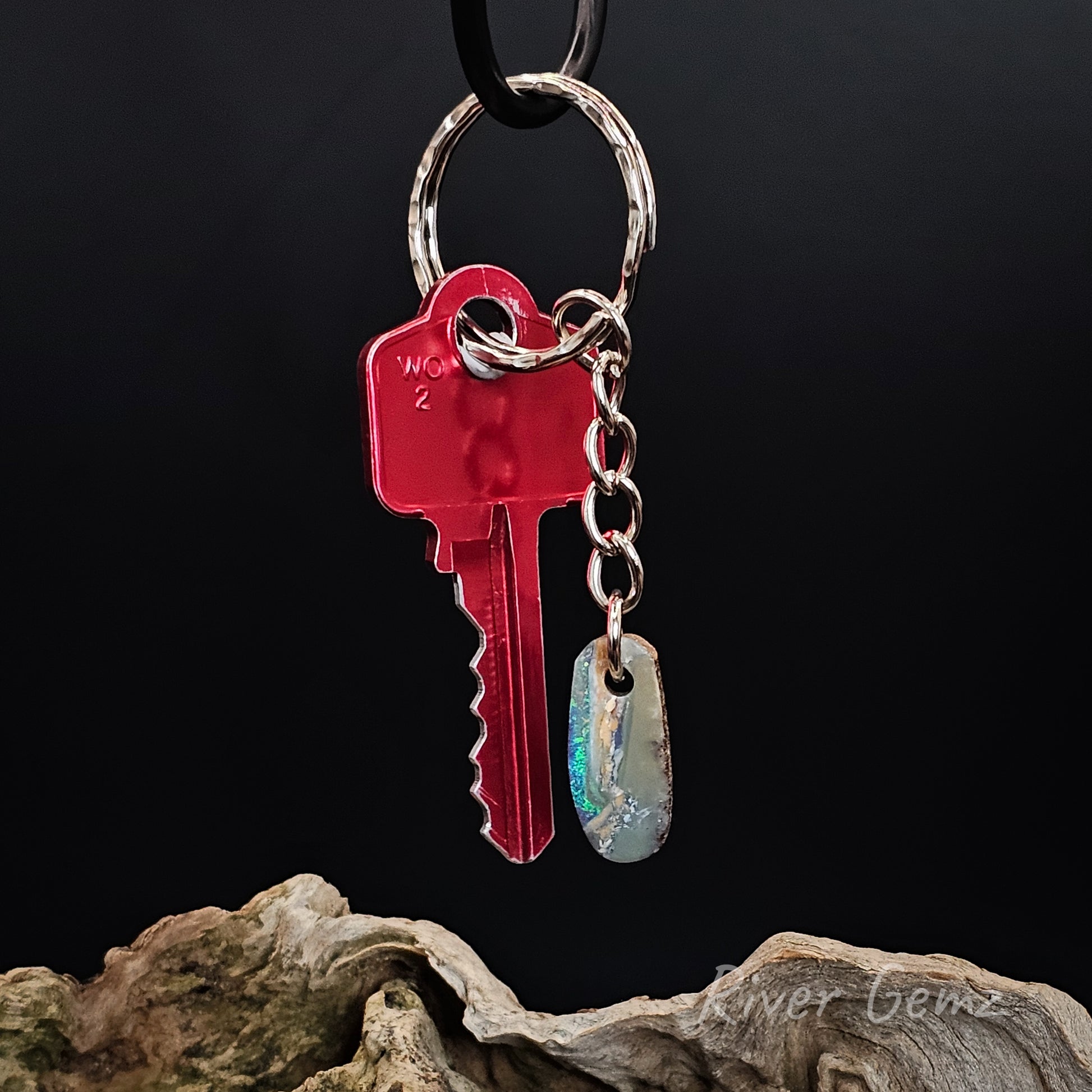 Red key and silver tag keychain on a dark background
