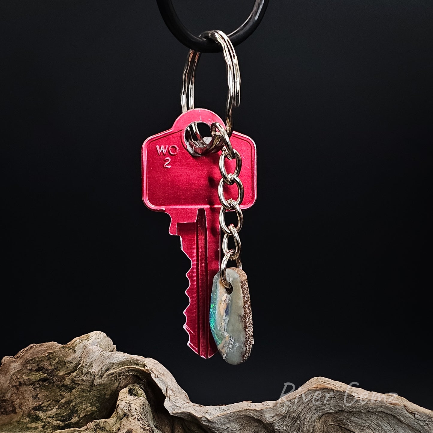 Keychain with a small boulder opal on a dark background