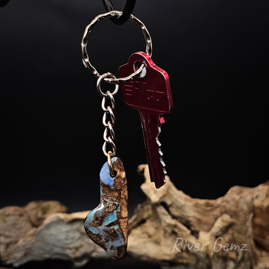 Keychain with a key and opal stone on a dark background