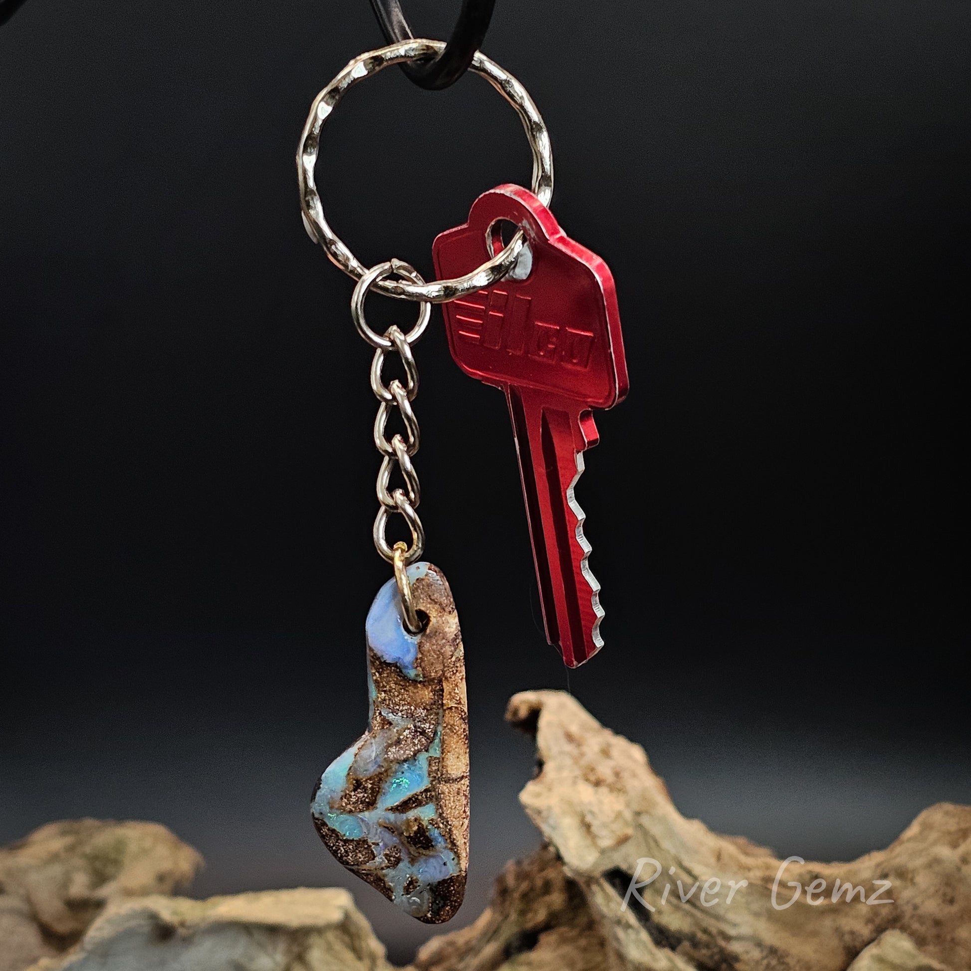 Keychain with a red key and natural stone pendant on a dark background