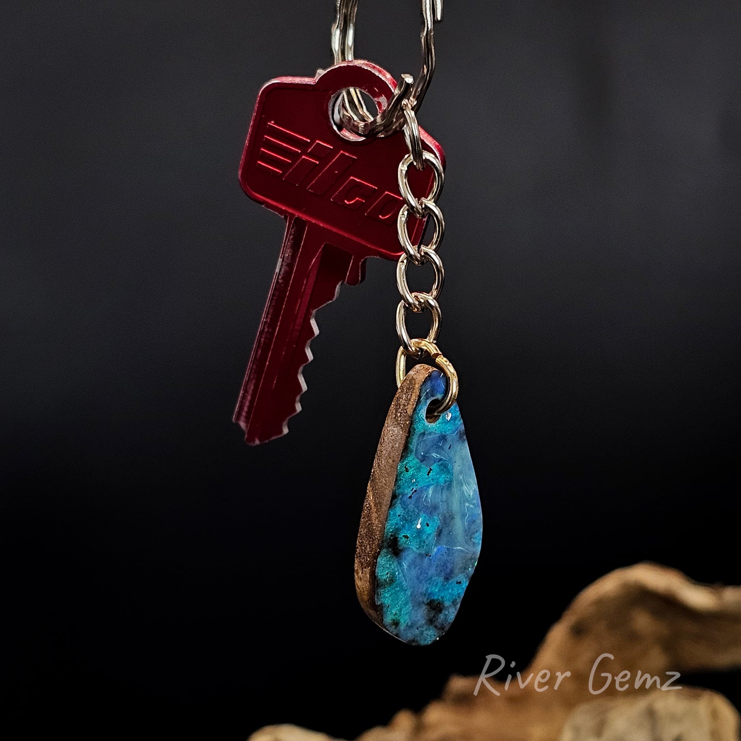 Keychain with a red key and blue stone pendant on a dark background