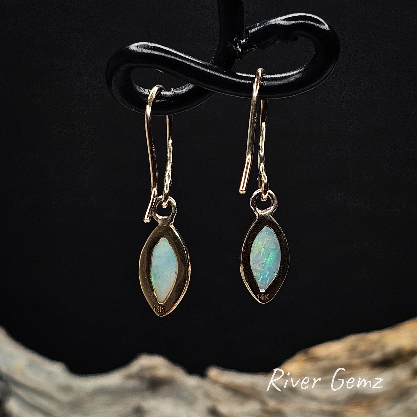 Rear view of hooks show 14K stamp to indicate gold and the light base tone of the crystal opals is visible.
