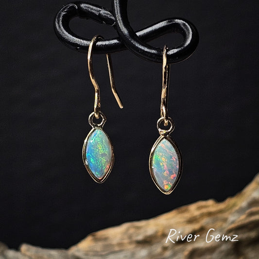 Marquise shaped multi-coloured crystal opals in hook earrings against a dark background with 'River Gemz' branding.