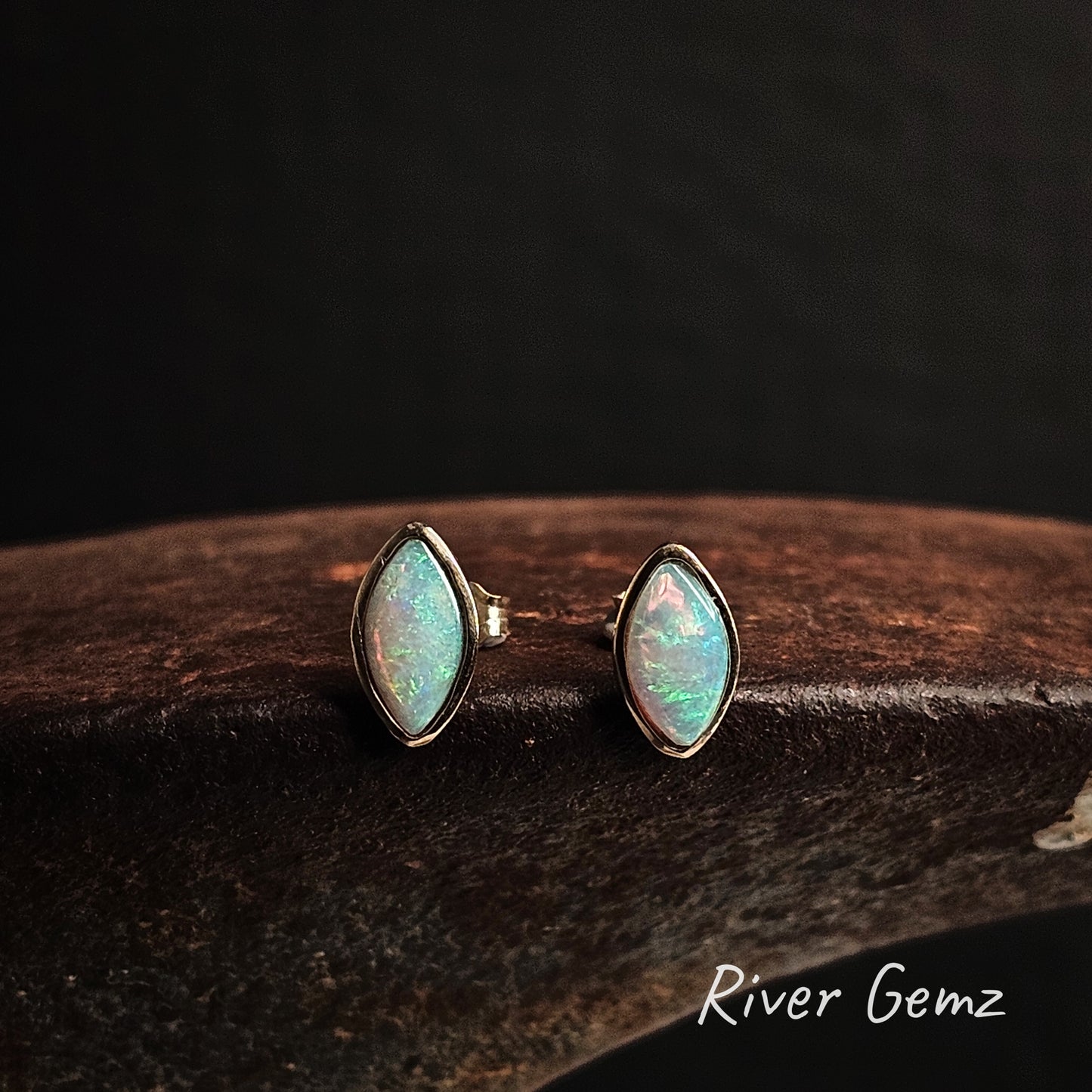 Marquise shaped light opals besel set in yellow gold on a cast iron shoe anvil.
