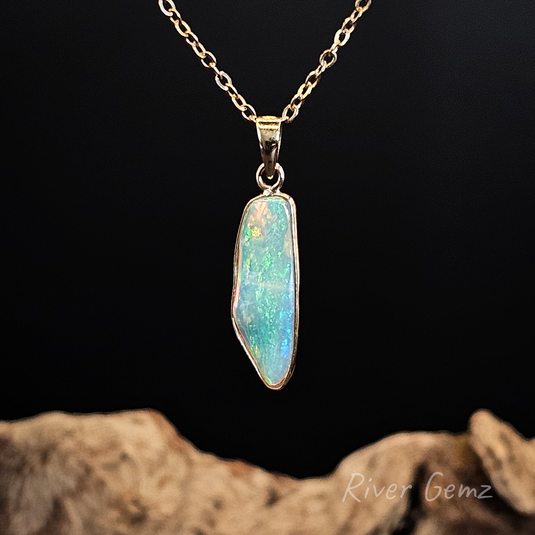 Opal pendant necklace on a chain with a dark background