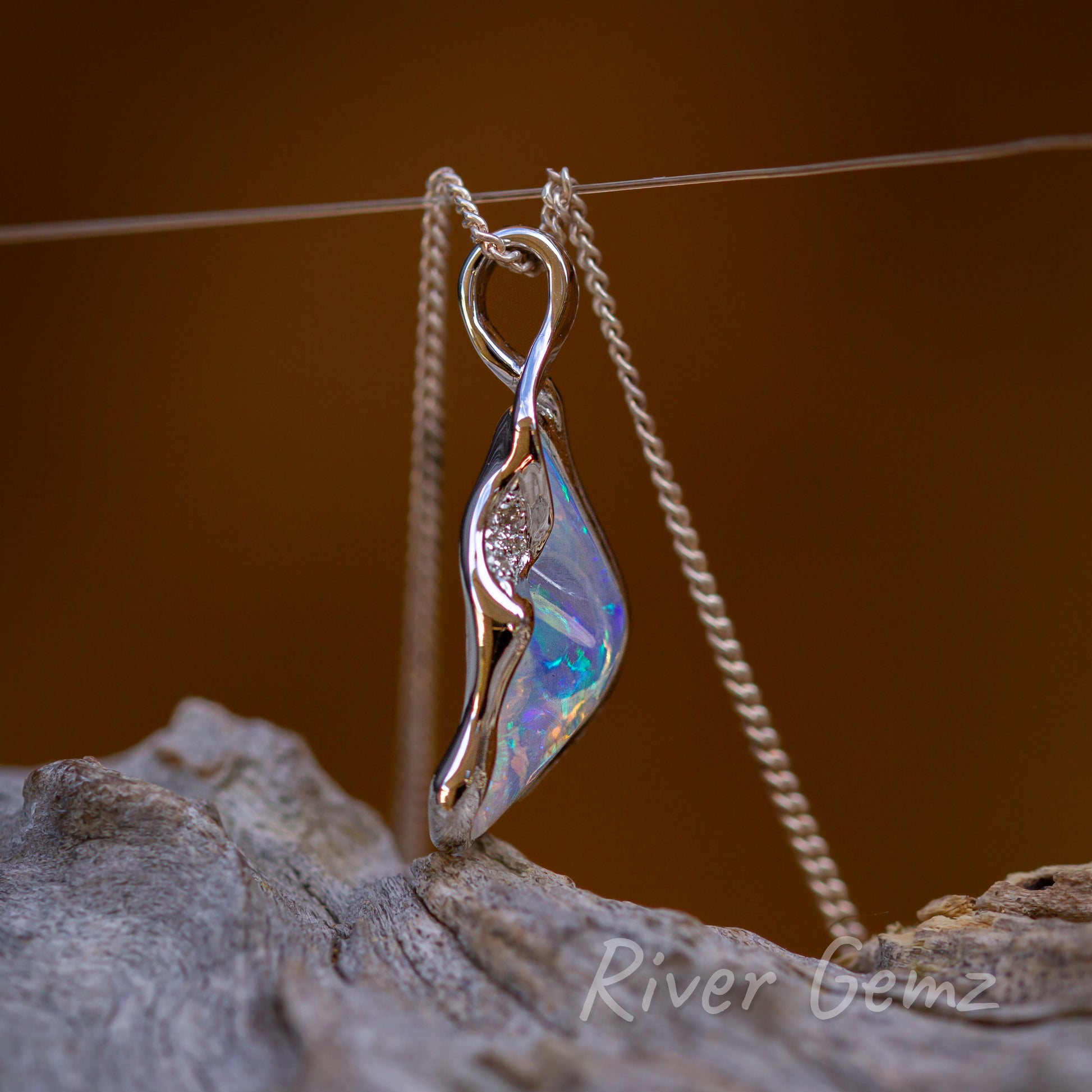 Side on view shows the large "loop" bail replacement. The high domed cabochon of the opal is like a bulging belly.