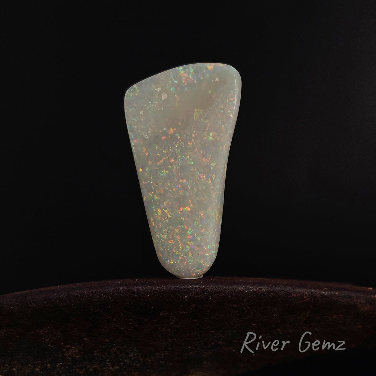 Large white opal standing upright against a black back-drop.